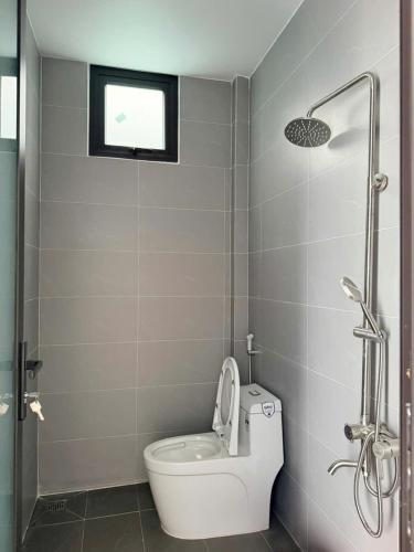a small bathroom with a toilet and a shower at Nhan's Home in Hưng Nhơn (2)