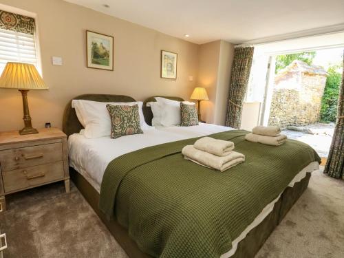 a bedroom with a large bed with towels on it at Little Wickers in Wareham