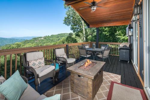 a deck with chairs and a table and a fire pit at Grey Fox in Banner Elk