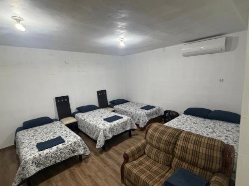 a room with three beds and a couch at Casa Tulipán in Monterrey
