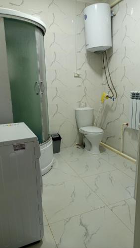 a white bathroom with a toilet and a sink at Bilalguesthouse in Dzhangyaryk