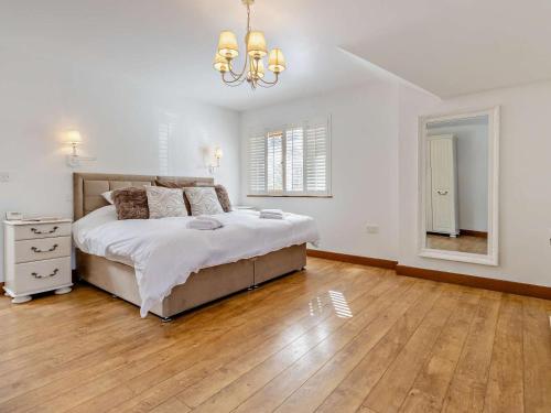 a white bedroom with a bed and a wooden floor at 4 Bed in Llanidloes oc-95968 in Van