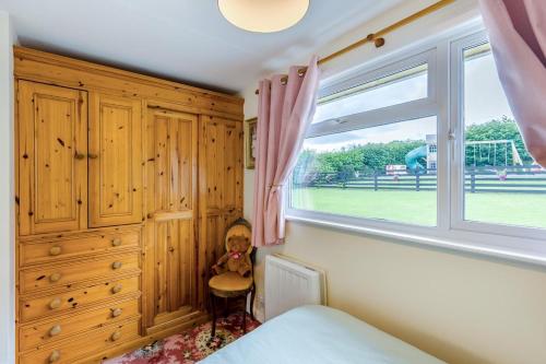 a bedroom with wooden cabinets and a window at 3 Bed in Brecon oc-bn363 in Brecon
