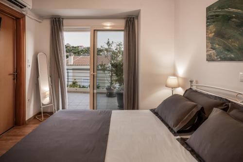 a bedroom with a large bed and a balcony at Βίλα Λαγονήσι in Kalívia Thorikoú