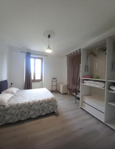 a white bedroom with a bed and a window at La Cascinassa in Tagliolo Monferrato