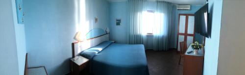 a blue room with a blue bed and a window at Il Gabbiano in Stalettì