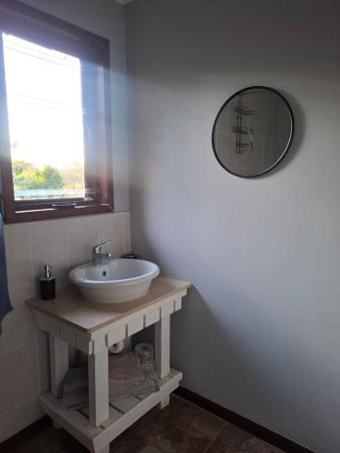 a bathroom with a sink and a mirror on the wall at The Cottage Eplazini in Port Shepstone
