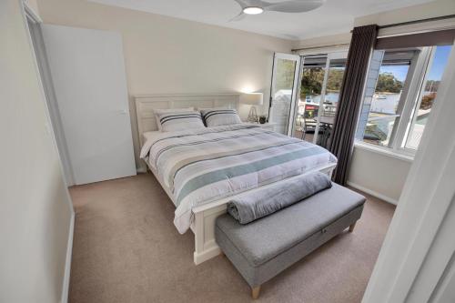 a bedroom with a large bed and a window at Bliss by the Bay in Metung