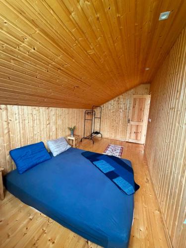 ein Bett in einem Holzzimmer mit Holzdecke in der Unterkunft Gomito mta in Ekadiya