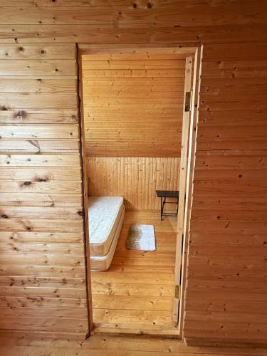 ein Holzzimmer mit einem Bett in einer Sauna in der Unterkunft Gomito mta in Ekadiya