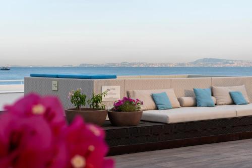 a couch sitting on top of a balcony with flowers at La Chiaja art&relais in Castellammare di Stabia