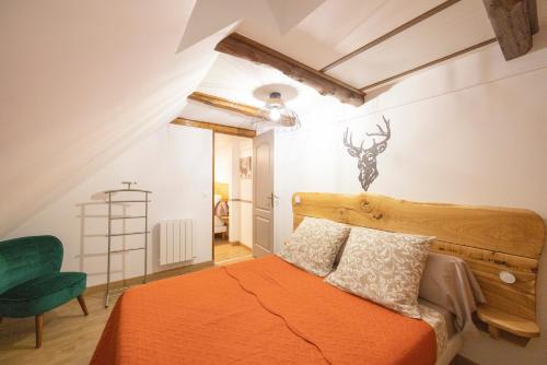 a bedroom with an orange bed and a green chair at Chambres D'hôtes Histoire D'anges in Singles