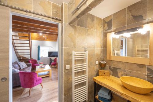 a bathroom with a sink and a living room at Chambres D'hôtes Histoire D'anges in Singles