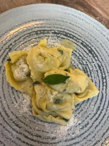 a plate of ravioli with cheese and basil on it at Bran Pensiunea Restaurant Al Gallo centru in Bran
