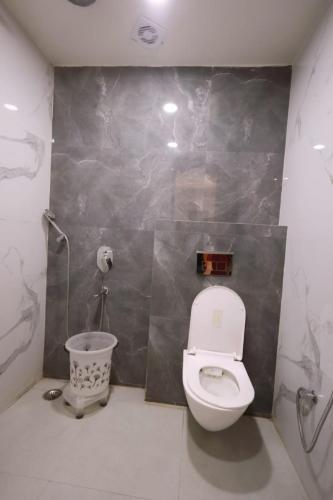 a bathroom with a toilet and a trash can at The Vatika Paradise in Ayodhya