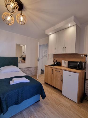 a bedroom with a bed and a kitchen with a microwave at Biały Port in Rajgród