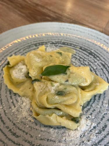 a plate of pasta with a green leaf on it at Bran Pensiunea Restaurant Al Gallo centru in Bran