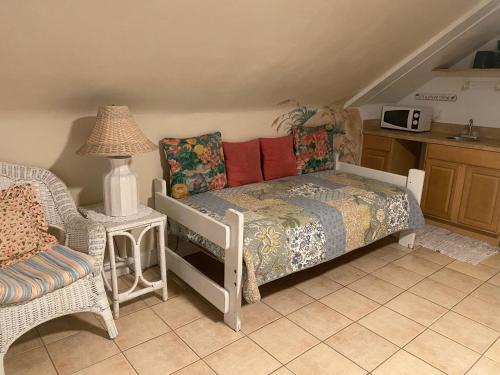a bedroom with a bed and a chair and a table at Angie's Guest Cottage in Virginia Beach