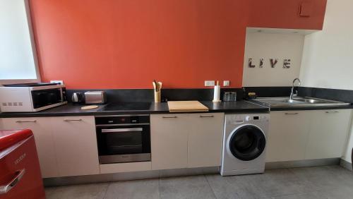 a kitchen with a washing machine and a sink at studio douillet en centre bourg in La Plaine-sur-Mer