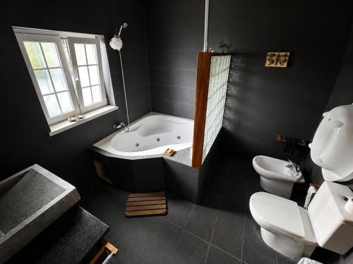 a bathroom with a tub and a toilet and a sink at Casa da Lua in Erra