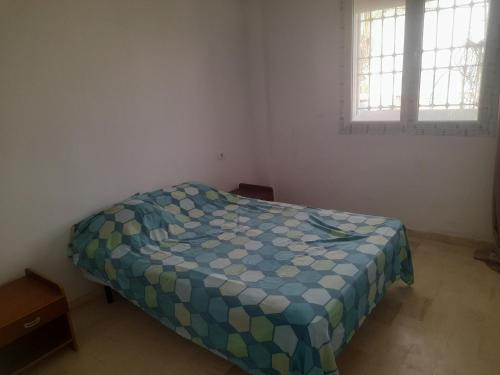 a bedroom with a bed in a room with two windows at Au Soleil le Vent in La Goulette