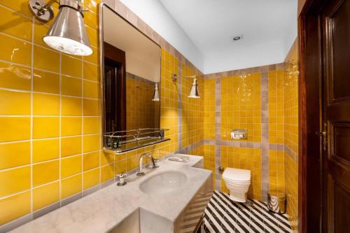 a yellow tiled bathroom with a sink and a toilet at House 5 Hotel in Antalya