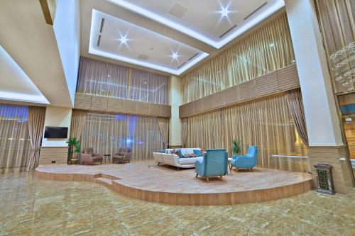 a lobby of a hotel with a couch and chairs at Ramada By Wyndham Iskenderun in İskenderun