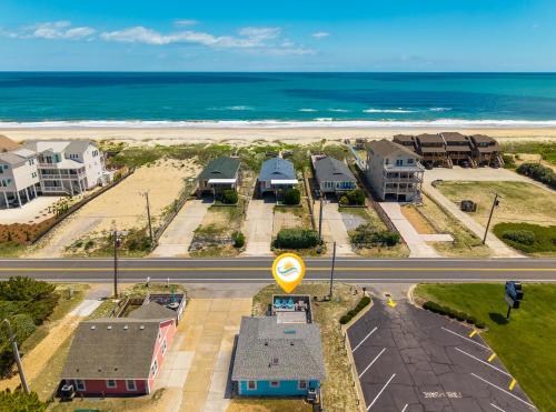an aerial view of a beach with houses and the ocean at 5065 - Flip Flop Inn in Kill Devil Hills