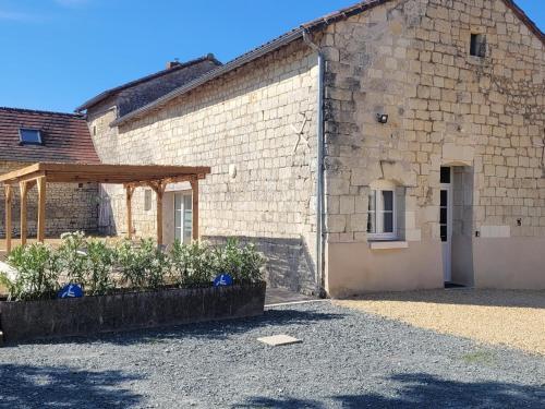 a large brick building with a door and a wooden structure at Gîte La Sellerie "4 étoiles" à la campagne "PMR" in Antran