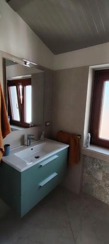 a bathroom with a white sink and a mirror at House biase e marrys in Trecchina