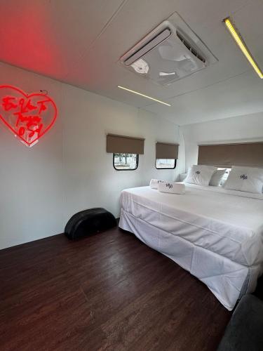 a bedroom with a large bed and a red heart on the wall at Roulotte Beach São Tomé in Triunfo