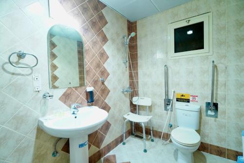 a bathroom with a toilet and a sink at فندق ندى الفيروز in Az Zāhir