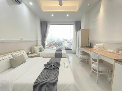 a hotel room with two beds and a desk and a window at 1001 Stars Hotel in Ho Chi Minh City