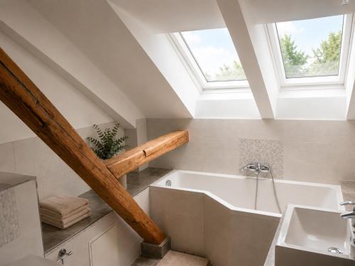 a bathroom with a bath tub and a sink at Bad Aibling City Apartment - Pano in Bad Aibling