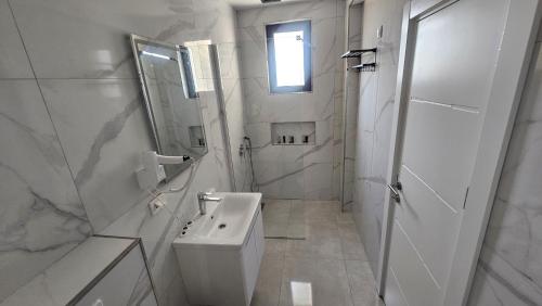 a white bathroom with a toilet and a sink at AnDora in Donji Štoj