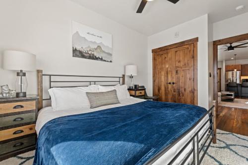ein Schlafzimmer mit einem großen Bett und einer blauen Decke in der Unterkunft Baker Loft 201 in Whitefish