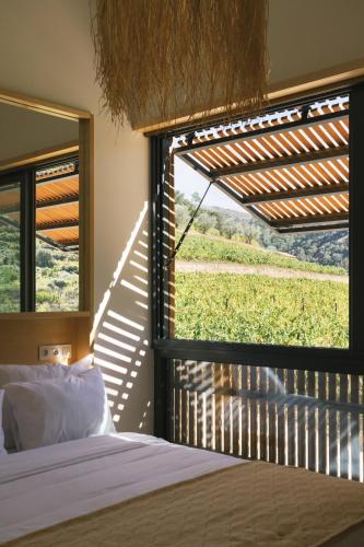 a bedroom with a bed and a window with a view at Casa do Lagar by Quinta de Recião in Lamego