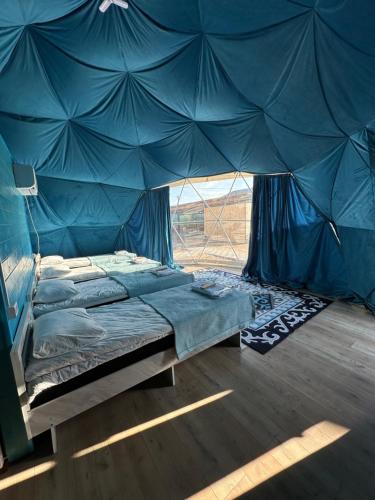 a bed in a tent in a room at Meykin Glamp in Cholpon-Ata