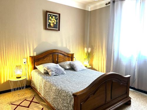 a bedroom with a bed with two pillows and a window at La maisonnette aux oiseaux - Vacances en Provence in Oppède