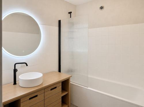 a white bathroom with a sink and a mirror at Cocon hyper centre de Pau avec parking in Pau