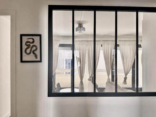 a window in a white room with curtains at Cocon hyper centre de Pau avec parking in Pau