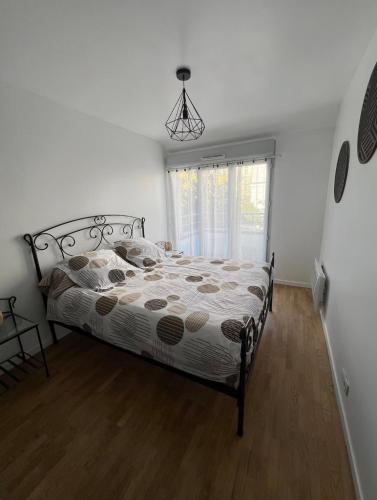a bedroom with a bed in a room with a window at La Maison Cocoon in Étampes