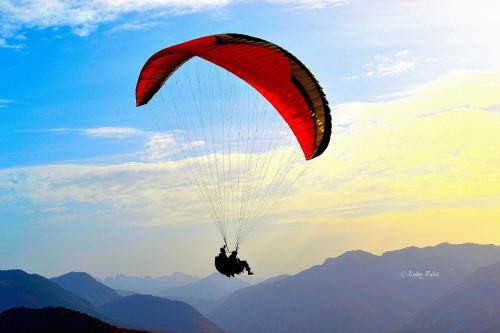 a person riding a parachute in the sky at Kraljska koliba - Kralje's Cottage in Andrijevica
