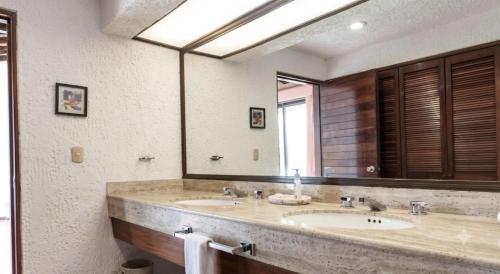 a bathroom with two sinks and a large mirror at The White Villa in Cancún