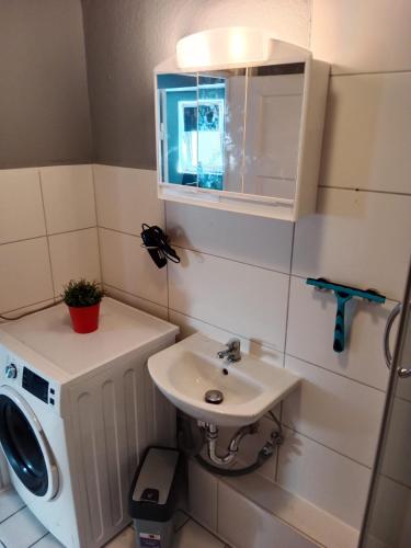 a bathroom with a sink and a washing machine at Stadtnest Katharine in Flensburg