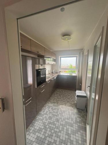a kitchen with a window and a tile floor at Ferienunterkunft International A in Bad Harzburg