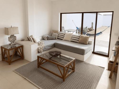 a living room with a couch and a table at Flip Flop House in Puerto Villamil