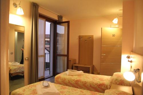 a hotel room with two beds and a bathroom at Albergo Verdi in Novi Ligure