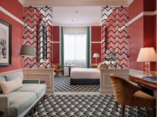a hotel room with a bed and a couch at The One Monumental Palace in Porto