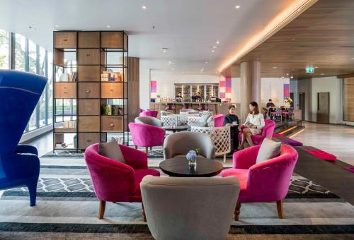 a lobby with pink chairs and a bar at U Nimman Chiang Mai in Chiang Mai